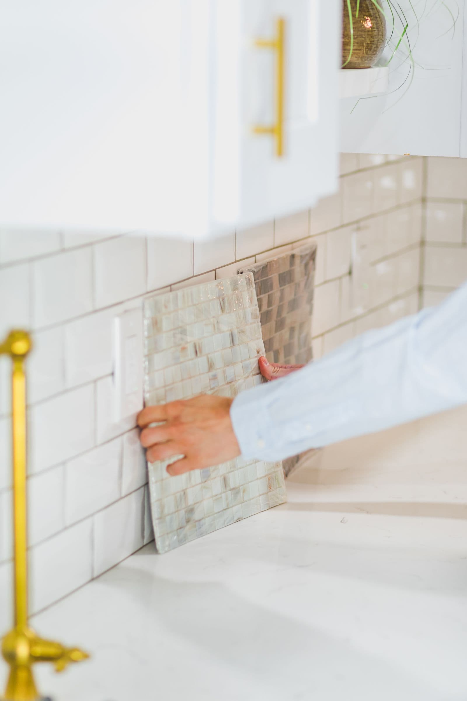 Installer fitting a mosaic tile sheet on a kitchen backsplash